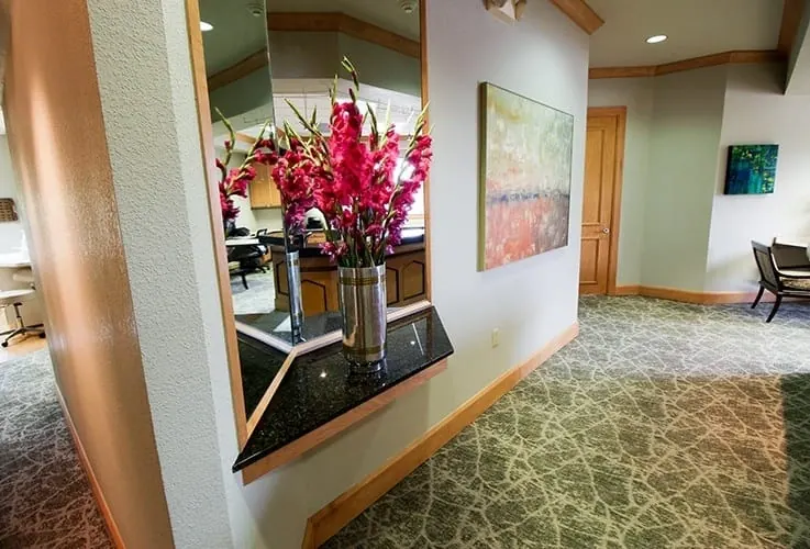 Flowers and artwork in the hallway at Grand Dental Studio.