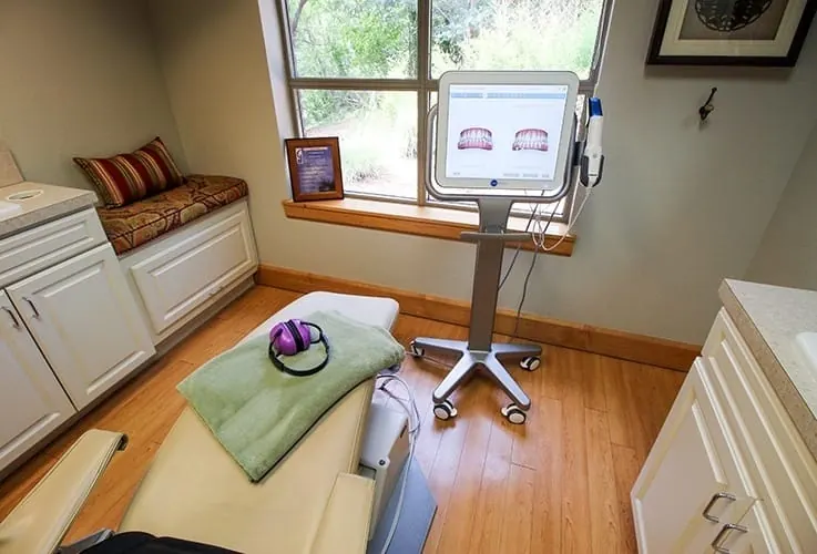 A treatment room with a comfort blanket on the chair and a chairside screen.
