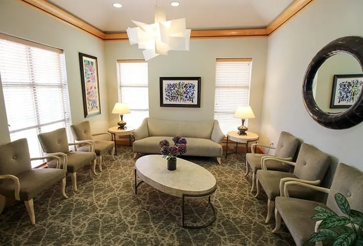 The waiting area, with armchairs, a sofa and a white sculptural light.